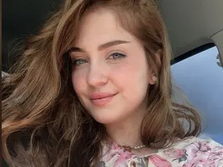 Innocenthish smiles while looking at the camera with her long brown hair falling over her shoulders.