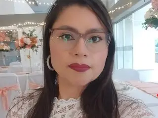 Woman in white lace outfit and glasses at an elegant wedding reception with fairy lights.