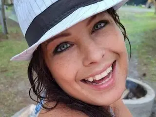 JadenDamon smiling outdoors while wearing a white sun hat.