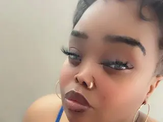 JazzyLUXE poses close-up, showing her face, dark hair, and nose ring while looking directly at the camera.