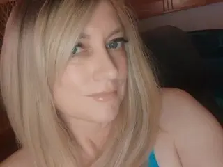 JenDoll poses with a close-up view of her face and blonde hair, looking directly at the camera with a soft smile.