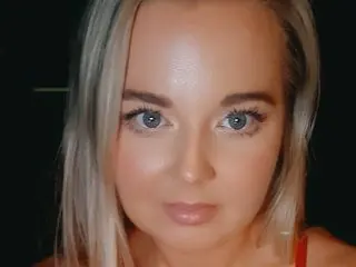 JessicaG69 looks directly at the camera with her blonde hair down, showing her face and shoulders in a close-up shot.