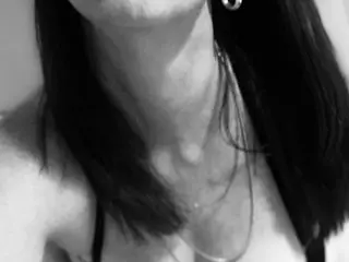 JettMonroe poses with her long dark hair falling over her shoulders, showing her neck and collarbone area in a close-up shot.