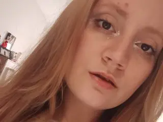 JulesJade shows her face and long blonde hair in a close-up selfie shot indoors.