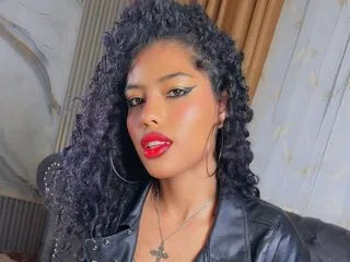 Julietajackson80 with long curly dark hair and red lipstick poses in a black leather jacket.