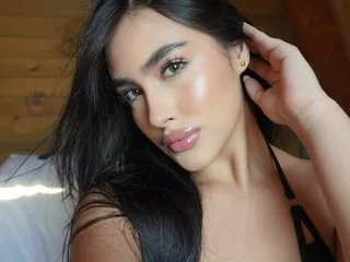 KaiaWhite — KaiaWhite poses with long dark hair and glossy lips while wearing a black strap top.
