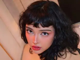 KaitlynStone19 poses closely to the camera, showing her face and dark wavy hair with blunt bangs.
