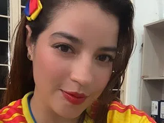 KarinaCardenas smiles in a yellow and red striped shirt with colorful hair clips in her dark hair.