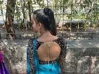 KendraBabyy — Young woman in a blue and black traditional Indian saree posing outdoors in a sunny garden setting.