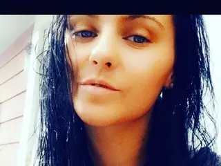 KrystallMayXoX looks directly at the camera with wet, dark hair framing her face in a close-up shot.