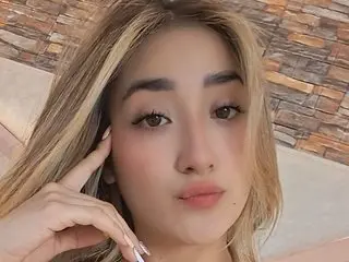 LUCYDAVIESS poses for a close-up selfie with her blonde hair framing her face against a textured stone wall background.