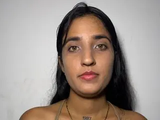 Lahlov looks directly at the camera with her long dark hair down against a plain white background.