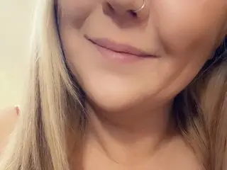 LaneyJoyxXx smiles closely at the camera, showing her blonde hair and face in a close-up shot.