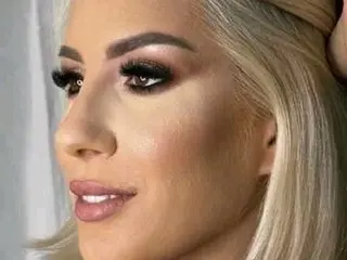 Lannie poses with a close-up headshot, showing her blonde hair and heavy eye makeup.