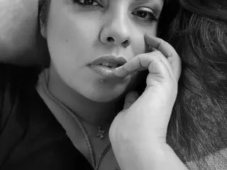 LaraValentine poses close-up, resting her chin on her hand with a soft expression and wet-look lips.