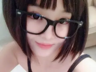 Layen, wearing black glasses and a black tank top, looks directly at the camera with her dark hair styled in a blunt bob.