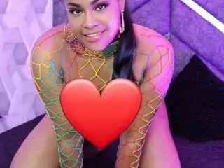 Laylasummer19 smiles while wearing a colorful fishnet bodysuit and gold jewelry in a purple room.