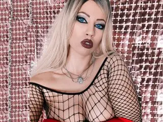LiaLennice poses in a black fishnet top that shows her cleavage, with her blonde hair styled down against a shimmering pink background.