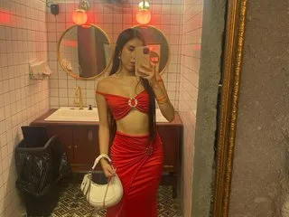 Lia_Santos poses in red lace lingerie while standing in front of a mirror in a bathroom setting.