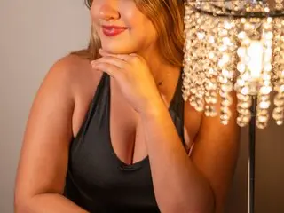 Liahfontaine poses with a smile, wearing a black tank top that shows her cleavage, with her hand resting under her chin.