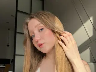 LilaMeow poses with her long blonde hair falling over her shoulders, looking directly at the camera with a soft expression.