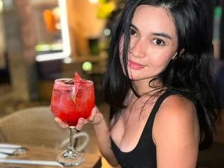LindaLove_GB smiles while holding a large red cocktail in a glass at a restaurant.