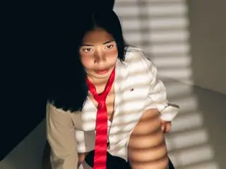 Lissalittlee poses in a white button-down shirt, looking at the camera with her dark hair down.