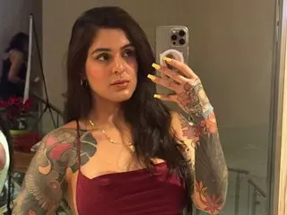 Lissanascott poses for a mirror selfie wearing a red tank top, showing her long dark hair and long manicured nails.
