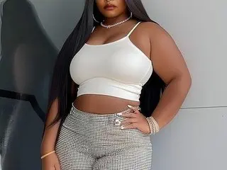 Lovelybigassxx poses in a white crop top and grey patterned leggings, showing off her long black hair and fit physique.