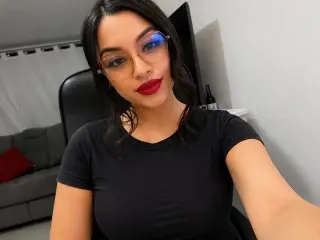 LunaVelvets poses for a close-up selfie, wearing a black t-shirt with her dark hair down and a direct gaze at the camera.