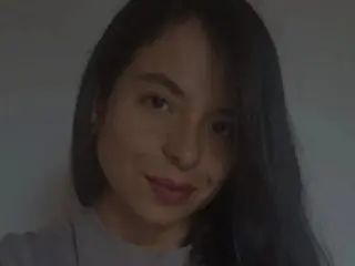 M_lolaa poses with her long dark hair down, looking directly at the camera in a close-up headshot.