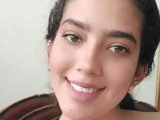 MaithePerroni smiles close up, showing her face, dark hair, and light skin in a headshot.
