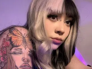 Maki_Uzui26 shows off her long, two-tone blonde and black hair and a large, colorful butterfly tattoo on her shoulder and neck.