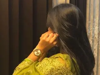 MandyLovv poses with her long black hair covering her face, wearing a lime green lace top or dress.