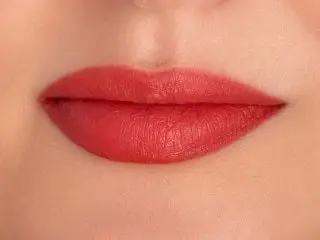 MargotStJames showing her red lips and smooth skin in a close-up shot.