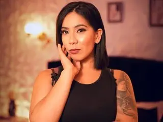 Marianaajackson poses with her hand on her face, wearing a black tank top and showing her shoulder tattoo.