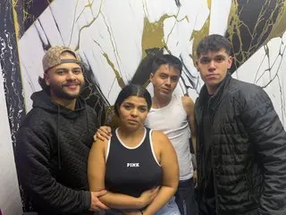 Four young friends smiling together in front of a modern black and gold marble wall background.