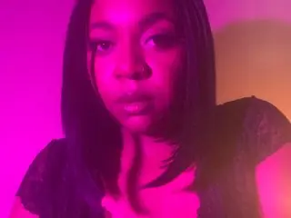 Mercedes_Redd poses with a close-up headshot, showing her dark hair and direct gaze against a pink and orange background.