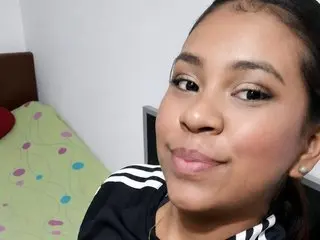 Smiling young woman in a black striped shirt relaxing in a bright bedroom.