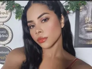 Mia_sexylatin poses with her long black hair down, showing her face and shoulders against a light background.