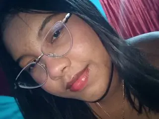 Miasexy21 wearing glasses and smiling at the camera with her long dark hair down.