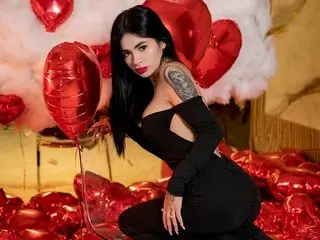 Woman in a black cutout dress posing with red heart balloons in a dreamy, romantic setting.