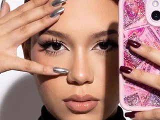Millyjohnson takes a close-up selfie with long silver nails and a pink glittery phone case.