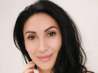 MiraWonderful smiles at the camera with her long black hair framing her face against a plain background.