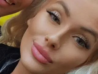 MissSquirtalot looks at the camera with a soft smile, showing her blonde hair and face in a close-up shot.