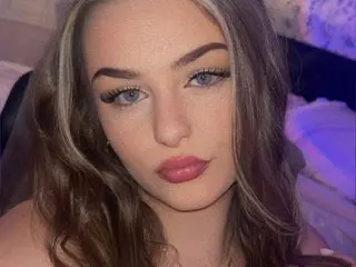 MissThiccc poses close-up with her long brown hair, showing her face and eyes while looking directly at the camera.
