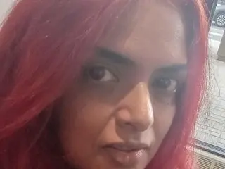 Mistress_Nadiaj shows her face and long red hair in a close-up selfie shot.