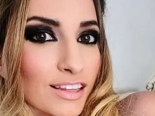 Msqudd poses with a close-up headshot, showing her blonde hair and dark eye makeup.