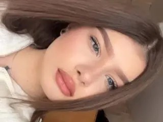 MySeline poses close-up with her long brown hair framing her face, showing her eyes and lips.