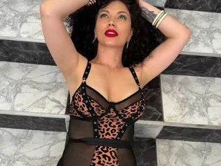 NataliaRed lies on marble stairs wearing a leopard print mesh bodysuit with her hands behind her head.